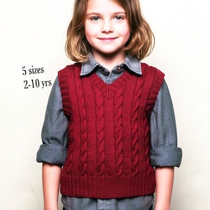 May include: A deep red cable-knit sweater vest with a V-neckline and ribbed hem. The garment features vertical cable patterns and is layered over a grey collared shirt. Text on the left side of the image reads 5 sizes 2-10 yrs.