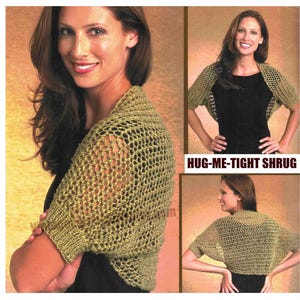 May include: A knitted olive green shrug with a mesh design. The image shows the shrug on a person, with the text "HUG-ME-TIGHT SHURG" in a white box. The shrug has short sleeves and a loose, open weave.