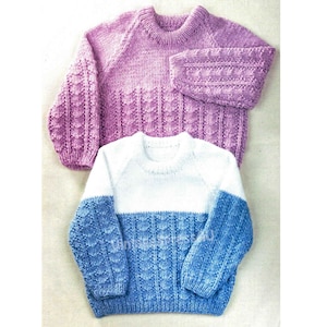 Może przedstawiać: Dwa dzianinowe swetry. Jeden jest lawendowy z teksturowanymi rękawami i teksturowym dołem. Drugi jest biały na górze i niebieski na dole, z teksturowanymi rękawami i teksturowym dołem.