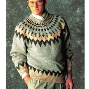 May include: A light blue sweater with a geometric pattern in black, tan, and light blue. The sweater has a crew neck and long sleeves. The pattern is repeated on the collar and cuffs. The sweater is worn over a white collared shirt.