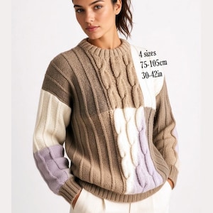 May include: A long-sleeve knit sweater featuring a color-blocked design in shades of beige, cream, and light purple. The garment displays vertical ribbed textures and cable knit patterns. Text on the image indicates 4 sizes, 75-105cm, 30-42in.