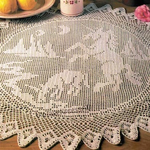 May include: A white crocheted doily with a delicate floral design. The doily is round and has a scalloped edge.