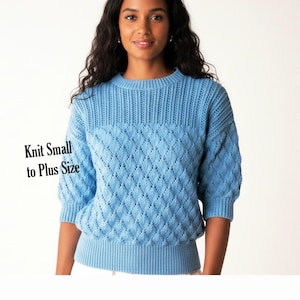 May include: A light blue knit jumper featuring a diamond-patterned texture on the body and sleeves, a ribbed crew neckline, ribbed cuffs, and a ribbed hem. The text "Knit Small to Plus Size" is printed in black on the left side of the image.