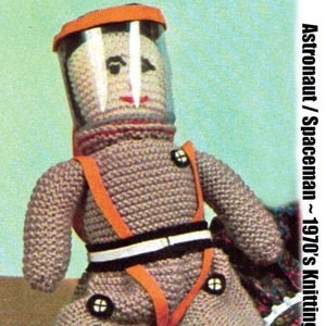 May include: A knitted astronaut doll with a clear helmet and orange accents. The doll is wearing a gray spacesuit with orange straps and black and white detailing. The text "Astronaut / Spaceman ~ 1970's Knitting" is visible.