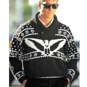 May include: A black long-sleeve sweater featuring a white eagle graphic on the chest and a white geometric pattern across the shoulders and sleeves. The sweater has a thick ribbed shawl collar with a single button closure at the neckline.
