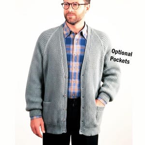 May include: A sage green button-down cardigan with a textured waffle knit pattern, long sleeves, and ribbed cuffs. The garment features a V-neckline and two front patch pockets. The text "Optional Pockets" is printed on the right side of the image.