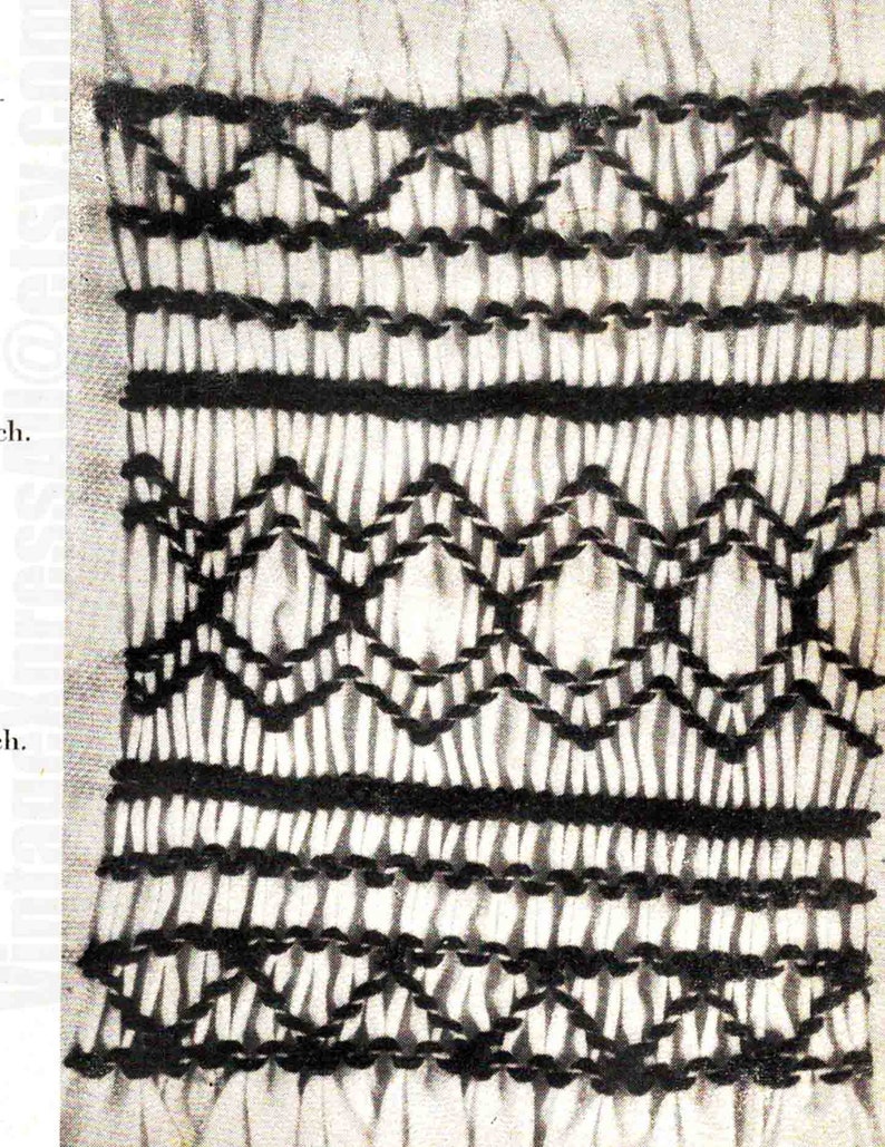 May include: A close-up of a white fabric with black embroidery. The embroidery is in a repeating pattern of diamonds and lines.