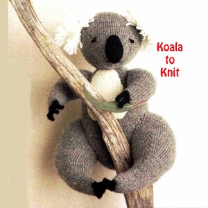 May include: A gray knitted koala bear with white fur ears, holding onto a branch. The koala is sitting on the branch with its legs wrapped around it. The text "Koala to Knit" is written in red letters on the right side of the image.