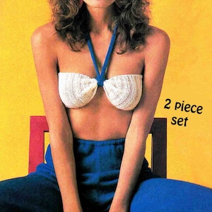 May include: A white crocheted halter top with a blue halter strap. The top is worn by a person sitting on a chair. The text "2 piece set" is visible in the image.