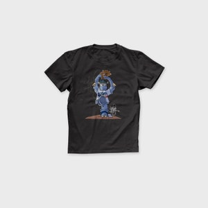 May include: Black t-shirt with a cartoon illustration of a baseball player wearing a blue and white uniform and a face mask, throwing a baseball. The player is wearing a blue and white baseball cap with the word "Dodgers" on it.