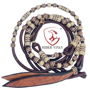 May include: A brown leather horse rein with white and brown braided beads. The rein has a decorative leather end with a floral pattern. The rein is coiled and ready to be used.