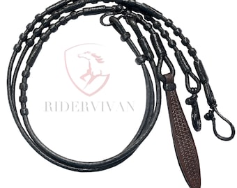 Könnte beinhalten: Schwarze Leder-Pferdezaumzügel mit einem braunen, strukturierten Lederakzent. Die Zügel sind aufwendig geflochten und geknotet, mit einer Schlaufe am Ende. Der Text "RIDERVIVAN" ist sichtbar.
