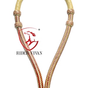 Puede incluir: Un cabezada de cuero trenzado para caballo con un patrón de color rojo y natural. La cabezada tiene un nudo redondo en la parte inferior y está hecha de un material tejido.