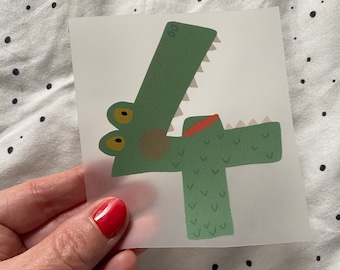 May include: Green crocodile shaped number four sticker. The crocodile has a red mouth and yellow eyes.