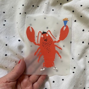 Könnte beinhalten: Ein roter Hummer mit einem weißen und schwarzen Bart, der weiße Turnschuhe trägt und ein blaues und weißes Eis am Stiel hält.