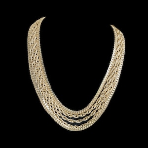 May include: A gold chain necklace with multiple strands of different chain styles.