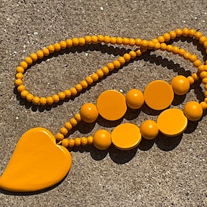 Colar longo de contas de madeira em forma de coração, cor mostarda, amarelo ocre
