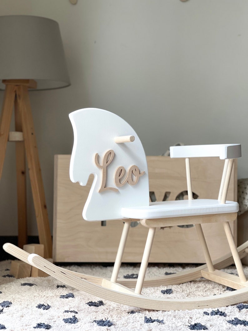 Personalised Wooden Rocking Horse painted in white colour. Safe for all ages 18 month and up. Features a comfortable riding seat that will make your child have a feel of thrilling riding and have long hours of fun.