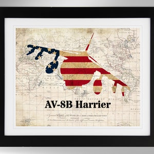 May include: A vintage world map with an American flag design in the shape of an AV-8B Harrier jet. The map is faded and has a distressed look.