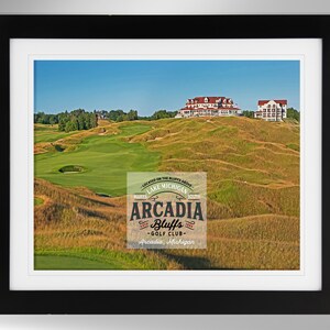 Puede incluir: Una vista panorámica de un campo de golf con una casa club en el fondo. El campo está situado en una colina con vistas a un lago. El logotipo del Arcadia Bluffs Golf Club está en primer plano.