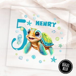Op de afbeelding: Een kleurrijke illustratie met een lachende cartoon zeeschildpad, de naam "HENRY" en het cijfer "5" in teal. Het ontwerp bevat bubbels, zeesterren, een kwal en een vis, allemaal in een maritiem thema.