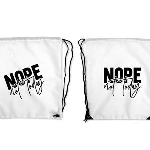 Puede incluir: Dos bolsas blancas de cord&oacute;n con correas negras. Las bolsas tienen el texto "NOPE not today" impreso en negro.