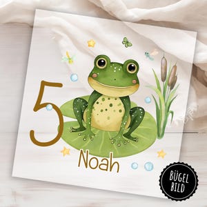 Könnte beinhalten: Eine farbenfrohe Illustration zeigt einen grünen Frosch mit gelben Punkten, der auf einem Seerosenblatt sitzt. Die Zahl "5" und der Name "Noah" sind abgebildet. Dekorative Elemente sind Sterne, Blasen, Libellen und Schilf. Das Bild ist wahrscheinlich für einen Kindergeburtstag.