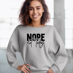 Puede incluir: Una sudadera gris con el texto "NOPE not today" impreso en negro.