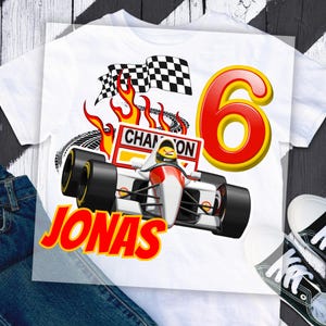 May include: White t-shirt with a racing car design, the name "Jonas" in red and yellow, a checkered flag, flames, and the number "6". The word "CHAMPION" is also visible in the design. A fun birthday theme.