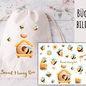 Könnte beinhalten: Ein Set Bügelbilder mit niedlichen Cartoon-Bienen und Honigwaben. Die Bügelbilder sind perfekt, um Kleidung, Taschen oder anderen Stoffartikeln einen Hauch von Verspieltheit zu verleihen. Die Bügelbilder sind mit "Sweet Honey Bee" beschriftet und beinhalten einen Bienenstock, einen Honigtopf und Bienen.