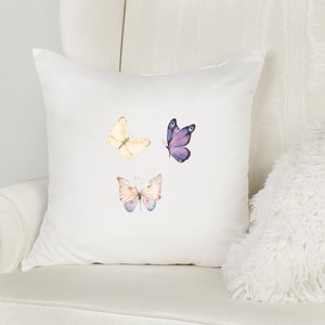 May include: White pillow with three watercolor butterfly designs. The butterflies are purple, yellow, and pink.
