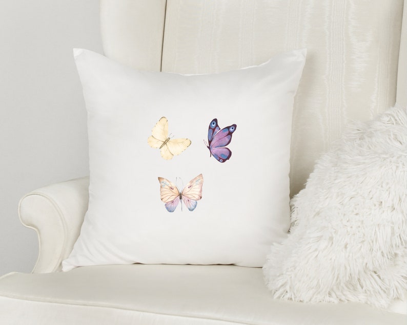 May include: White pillow with three watercolor butterfly designs. The butterflies are purple, yellow, and pink.