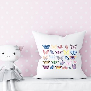 May include: White pillow with a colorful butterfly pattern. The butterflies are in various shades of pink, blue, yellow, and green. The pillow is on a pink background with white polka dots.