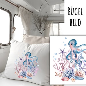 Può includere: Un'illustrazione ad acquerello di un polpo con tentacoli rosa e blu circondato da coralli e stelle marine. Il polpo è su uno sfondo bianco con il testo "BÜGEL BILD" sopra.
