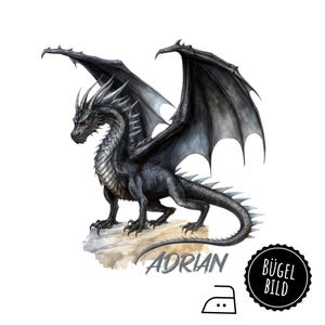Könnte beinhalten: Schwarzer Drache mit grauen Flügeln und roten Augen, der auf einem Felsen steht, unter dem der Name "Adrian" steht. Das Bild ist für einen Bügeltransfer.