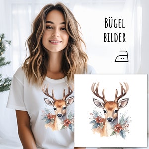 Könnte beinhalten: Weißes T-Shirt mit einer Aquarell-Illustration eines Hirsches mit Geweih und floralen Akzenten. Der Text "BÜGEL BILDER" ist in Schwarz dargestellt. Ein Bügeleisensymbol ist ebenfalls vorhanden.