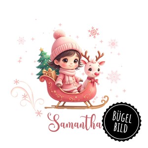 Könnte beinhalten: Ein rosa-weißer Weihnachts-Bügelbild mit einem Mädchen in rosa Mütze und Mantel, das in einem roten Schlitten fährt, der von einem Rentier gezogen wird. Das Mädchen hält ein Geschenk und der Schlitten ist mit Schneeflocken verziert. Der Text "Samantha" steht unter dem Schlitten.