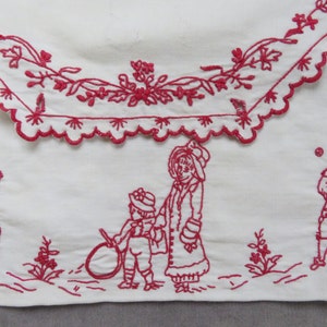 May include: Red embroidered design on white fabric featuring children playing. A girl in a dress is skipping, a boy is playing with a hoop, a girl is holding a boy's hand, and a boy is playing with a ball.