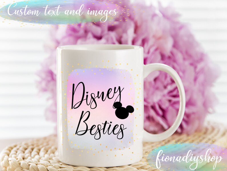 May include: White ceramic mug with the text "Disney Besties" in black script, featuring a Mickey Mouse silhouette. The design is set against a pastel watercolor background with gold speckles. The mug has a curved handle.