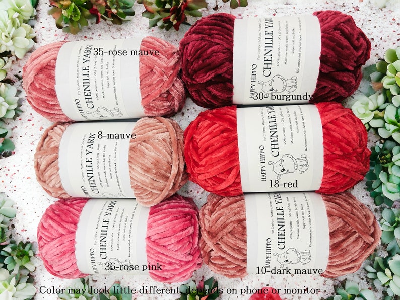 Op de afbeelding: Zes spoelen chenille garen in verschillende tinten rood en mauve. De spoelen zijn gelabeld met de merknaam "Happy Hippo" en de kleur en het nummer van elk garen. De kleuren omvatten: 35-roze mauve, 8-mauve, 36-roze roze, 10-donker mauve, 30-burgundy en 18-rood.