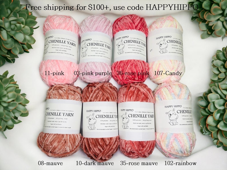 Op de afbeelding: Acht spoelen chenille garen in verschillende kleuren, waaronder roze, paars, roze, mauve en regenboog. Elke spoel heeft een label met de merknaam "Happy Hippo" en de garenkleurnaam.
