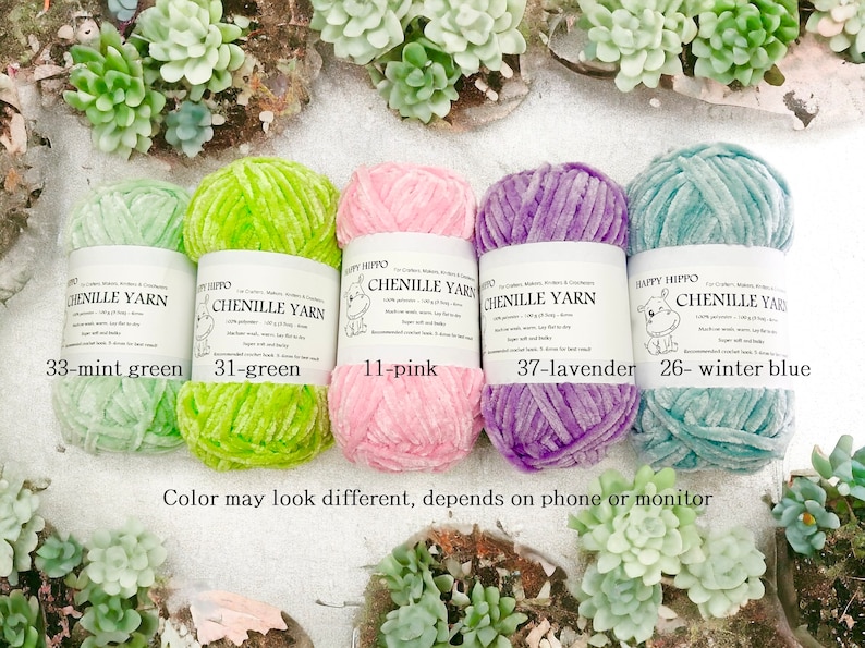 Op de afbeelding: Vijf spoelen chenille garen in verschillende kleuren: mintgroen, groen, roze, lavendel en winterblauw. Elke spoel heeft een label met het Happy Hippo-logo en de kleurnaam.