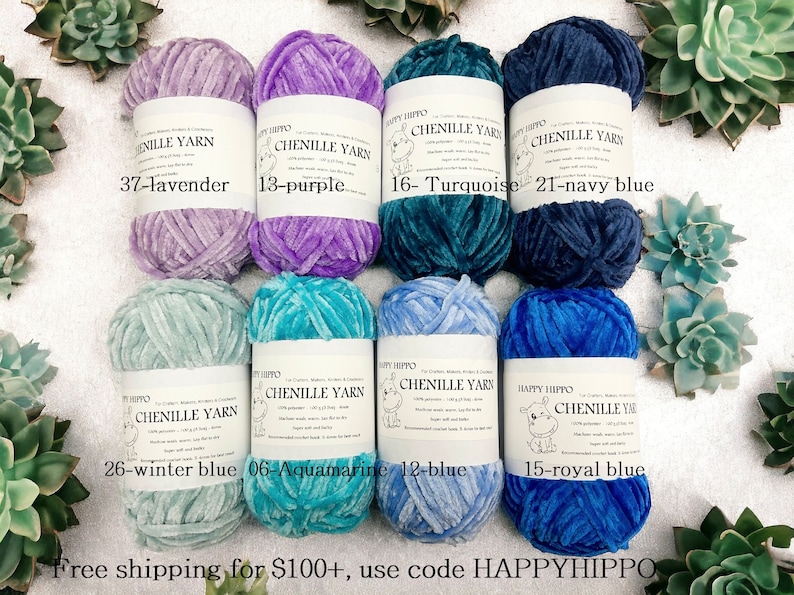 Op de afbeelding: Acht spoelen chenille garen in verschillende kleuren, waaronder lavendel, paars, turquoise, marineblauw, winterblauw, aquamarijn, blauw en koninklijk blauw. Elke spoel heeft een label met de merknaam "Happy Hippo" en de kleurnaam en het nummer.