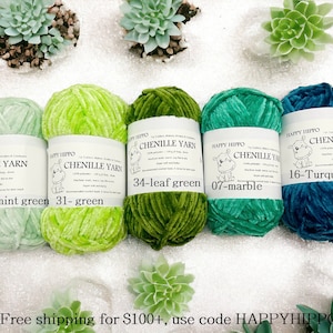 Op de afbeelding: Vijf spoelen chenille garen in verschillende tinten groen en turquoise. Het garen is gelabeld met de merknaam "Happy Hippo" en de kleurennamen: "33-mint green", "31-green", "34-leaf green", "07-marble" en "16-Turquoise".