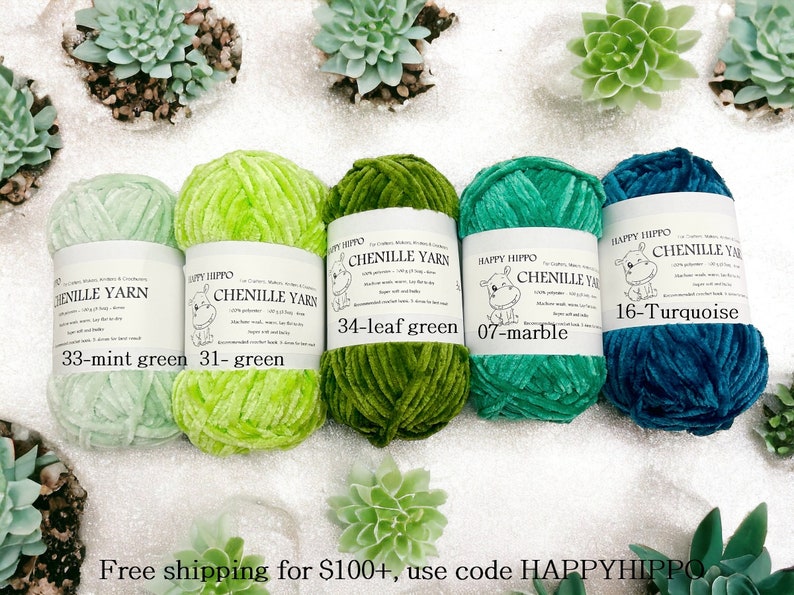 Op de afbeelding: Vijf spoelen chenille garen in verschillende tinten groen en turquoise. Het garen is gelabeld met de merknaam "Happy Hippo" en de kleurennamen: "33-mint green", "31-green", "34-leaf green", "07-marble" en "16-Turquoise".
