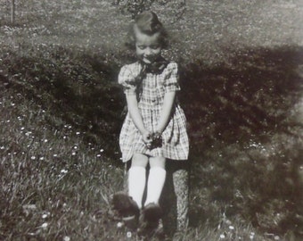 Adorable Little Girl With A Sweet Smile Sits On A Tree Stump Under A Tree 1945 Snapshot Photo