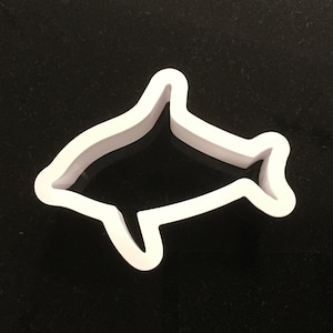 May include: White plastic dolphin cookie cutter.