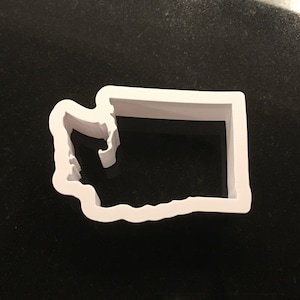 May include: White plastic cookie cutter shaped like the state of Washington.