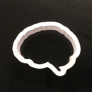 May include: White plastic cookie cutter shaped like a brain.