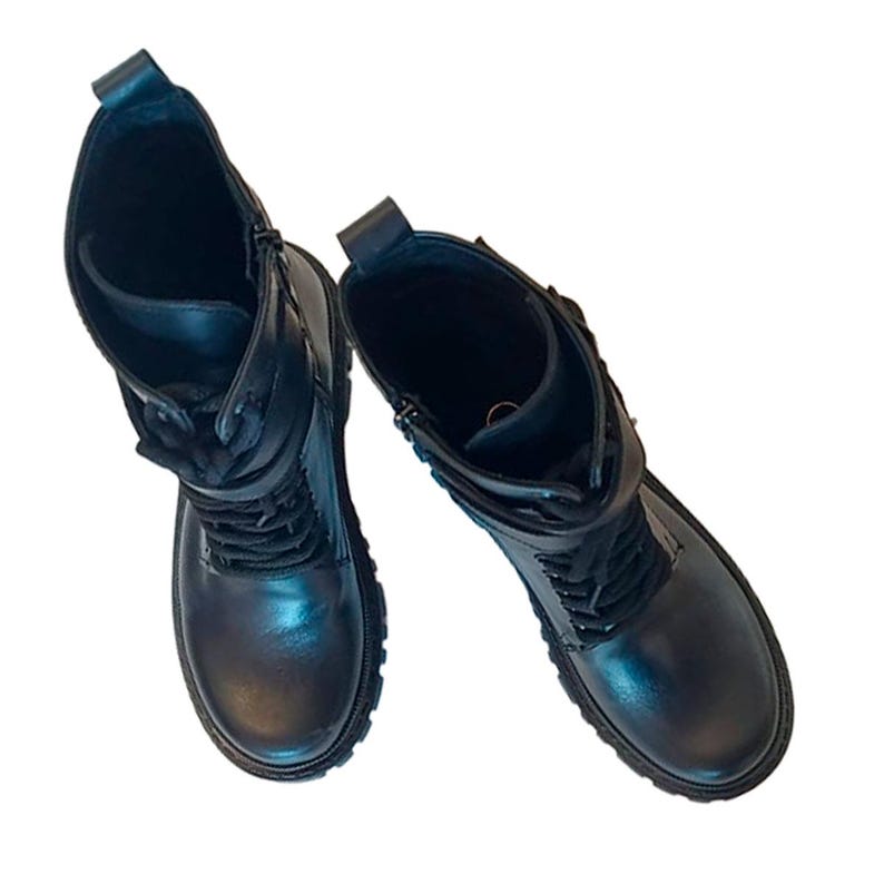 K&ouml;nnte beinhalten: Ein Paar schwarze Leder-Kampfstiefel. Die Stiefel haben ein Schn&uuml;rdesign, einen seitlichen Rei&szlig;verschluss und eine runde Spitze. Die Sohlen sind dick und die Stiefel haben einen kurzen Schaft. Die Stiefel sind vor wei&szlig;em Hintergrund.